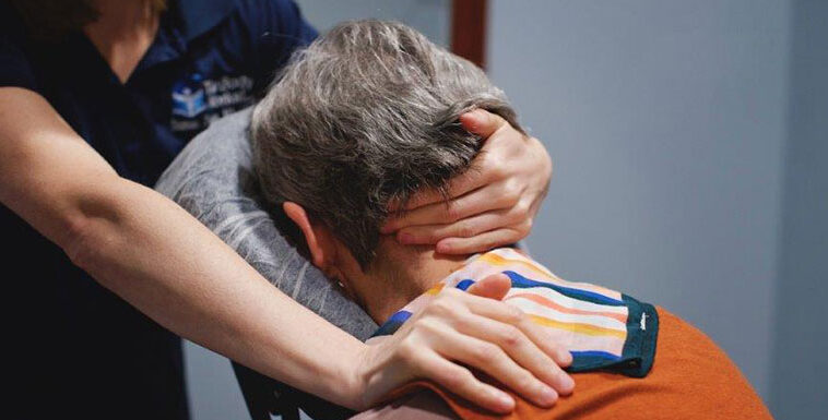A woman is getting her neck massaged by a therapist.