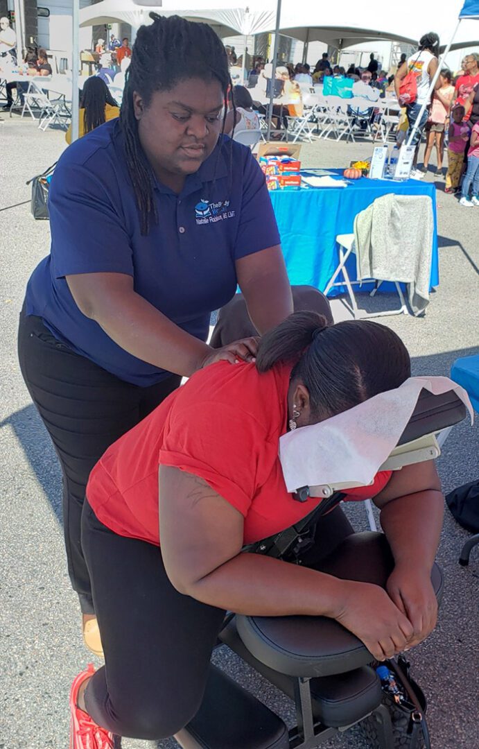 A woman sitting in a chair getting a massage.