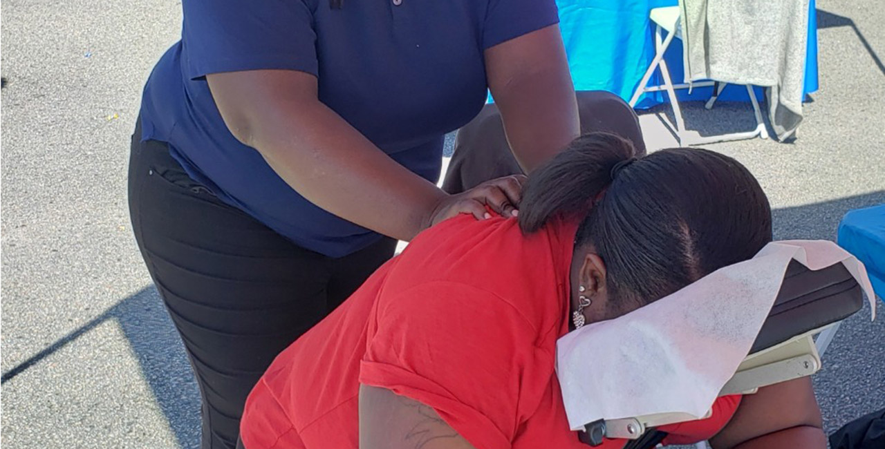 A woman getting a massage at an outdoor event.