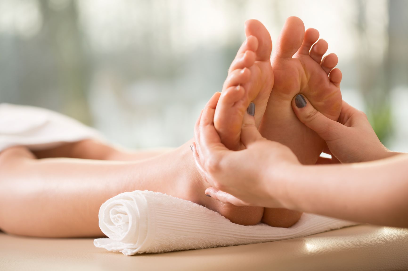 A woman getting a foot massage in a spa.