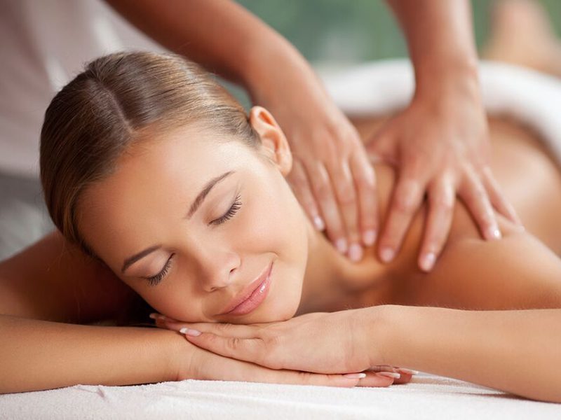 A woman getting a back massage at a spa.