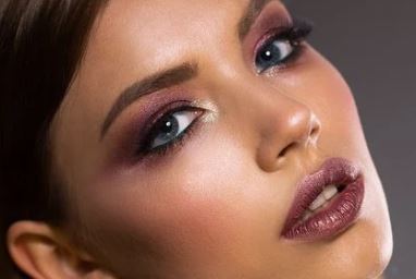 A woman with a plum colored eye makeup.