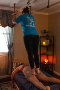 A woman doing a tai chi massage on a bed.