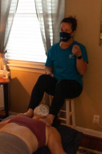 A woman sitting on a bed with a mask on her face.