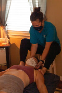 A woman with a mask on her face getting a massage.