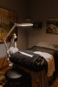 A bed in a room with a lamp on it.