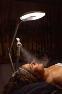 A woman lying on a bed with steam coming out of her hair.