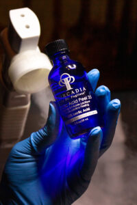 A person holding a bottle of blue liquid.