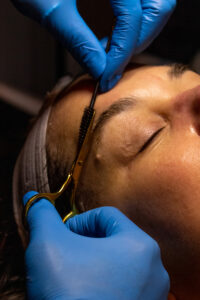 A woman getting her eyebrows waxed.