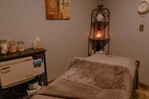 A room with a massage table and a candle.