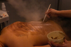 A man is getting a steam treatment on his back.