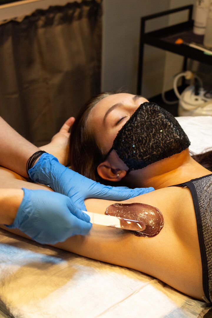 A woman is getting a tattoo on her arm.