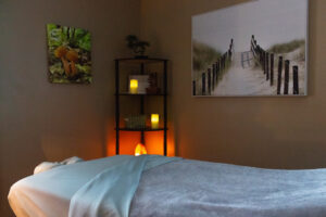 A massage room with candles and a picture on the wall.