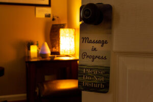 A sign on a door that says "massage in progress please do not disturb".