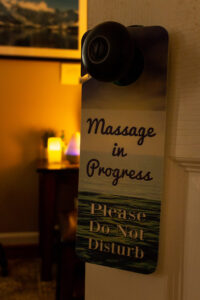 A door sign that says massage in progress please do not disturb.