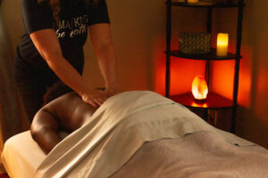 A woman getting a massage in a room with candles.